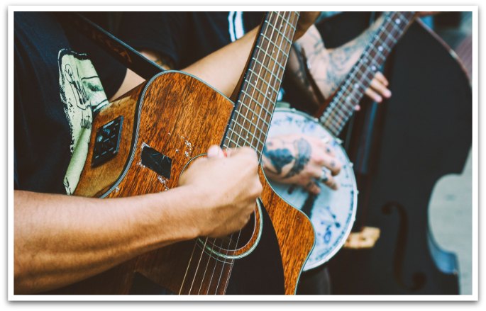 Close up of a guitar and banjo being played.