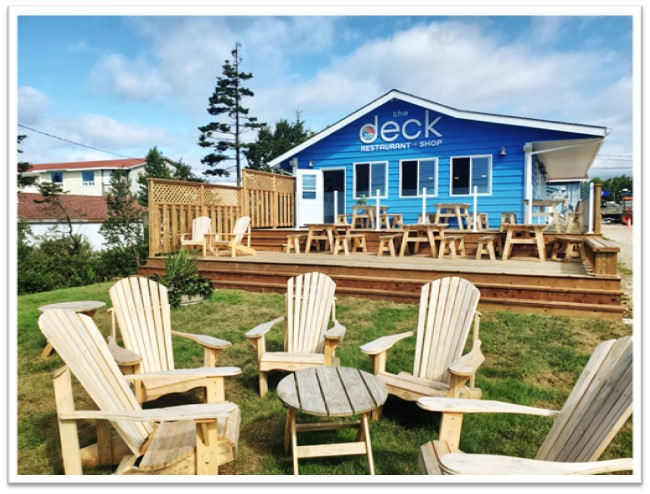 Exterior of The Deck, a blue building, with patio furniture on its deck.