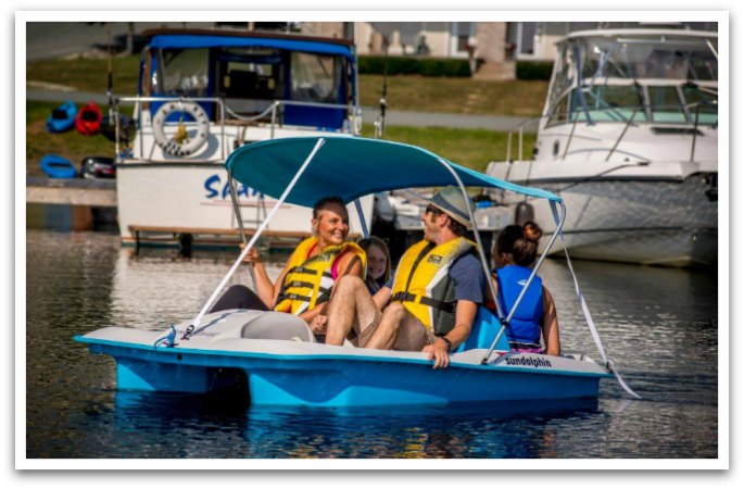 Family laughing in a pedal boat